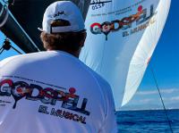 Teatro del Soho CaixaBank, liderado por Javier Banderas y favorito en Copa del Rey de vela, lleva el musical Godspell a sus velas.