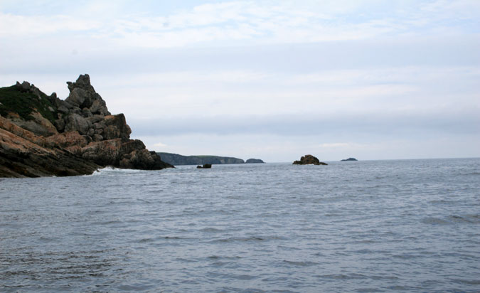 Punta del Cuerno desde el E. Al fondo Punta Romanellas y sus islotes. Punta del Cuerno desde el E. Al fondo Punta Romanellas y sus islotes.