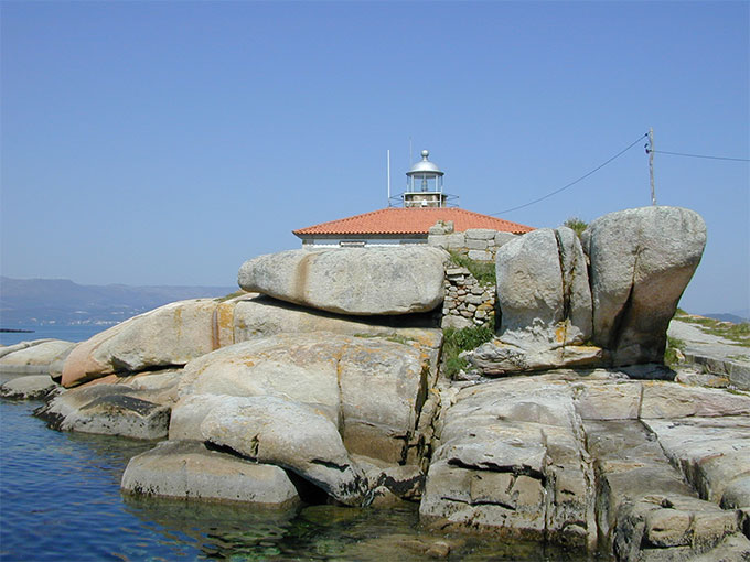 Linterna asomándose sobre las rocas Linterna asomándose sobre las rocas